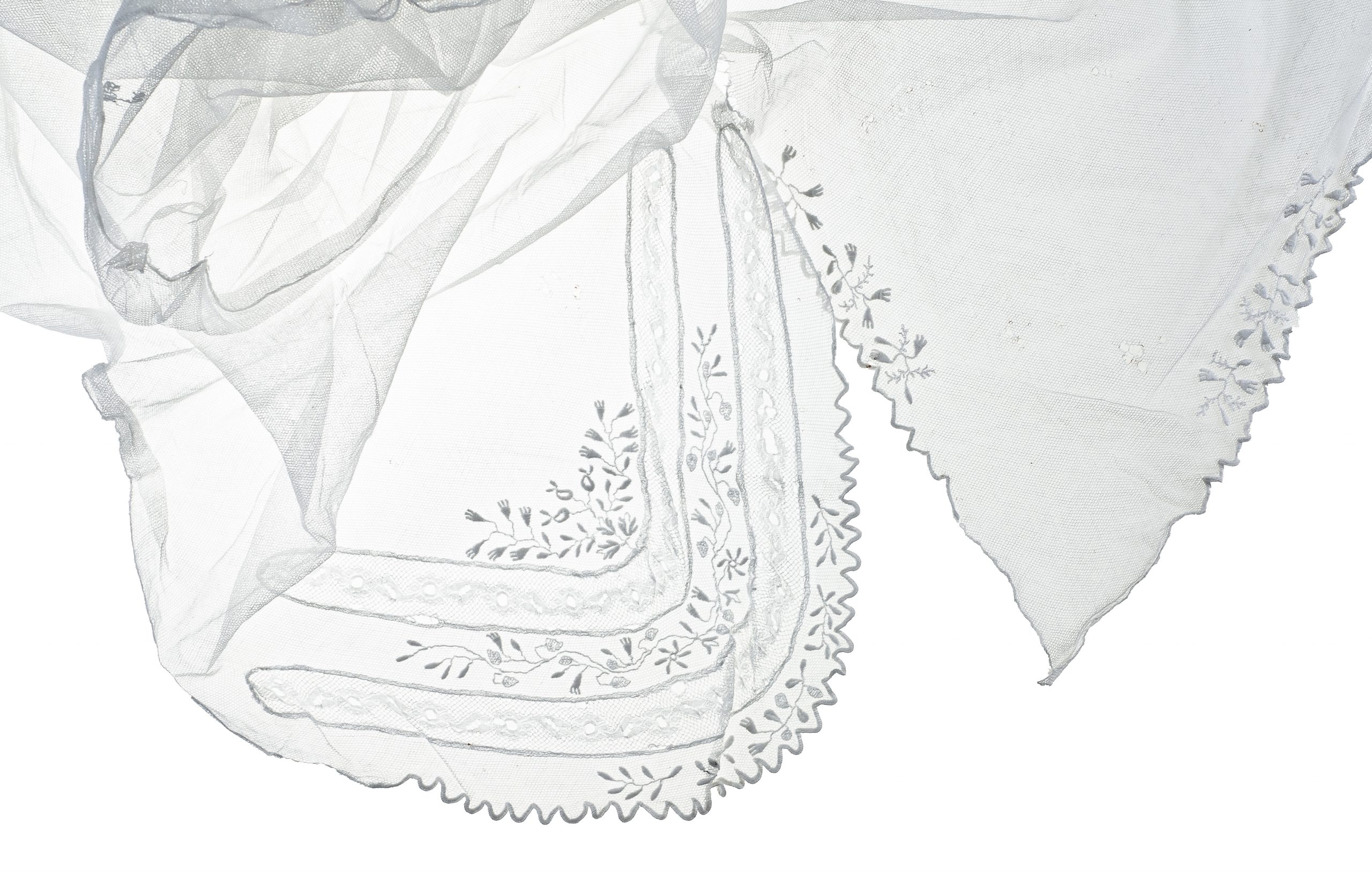 1056 etnografia - fragment chusty czepcowej, szerzyny, wyrób fabryczny, na biały delikatny tiul  naniesione są ornamenty znajdujące się w trzech narożnikach chusty, wys. 120, szer. 120 cm