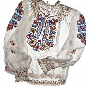 1181 etnografia - bluzka, zakopane, sprzed 1939 r., na białym batyście widnieje wyszyty ręcznie kolorowy haft, wys. 52 cm, szer. 56 cm