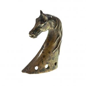 756 etnografia - głowa konia z mosiądzu, główna ozdoba i zarazem wykończenie homonta końskiego, dębowiec, sprzed 1936 r., wys. 8,5 cm, szer. 5,5 cm, gł. 2,5 cm